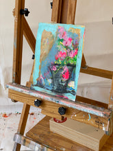 blue painting with pink flowers on easel