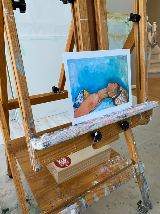 beautiful girl reclining in print on paper setting on easel